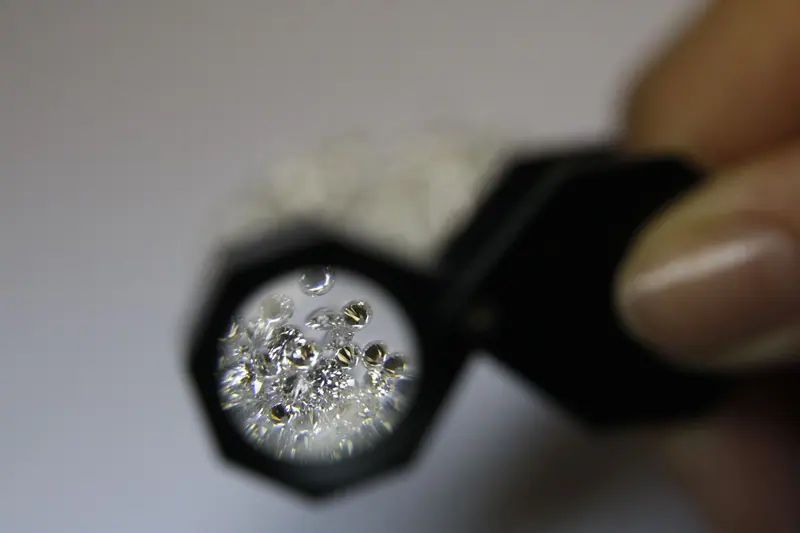 Loose diamonds seen through a jeweler's loupe